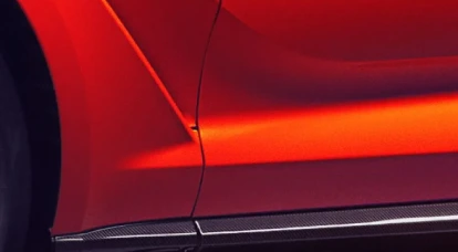 Upclose view of side of an orange Aston Martin DBX707