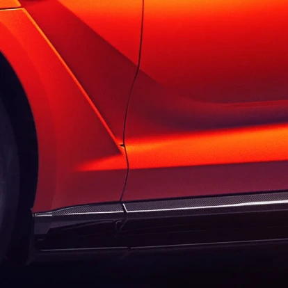 Upclose view of side of an orange Aston Martin DBX707