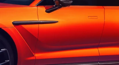 Upclose view of side of an orange Aston Martin DBX707