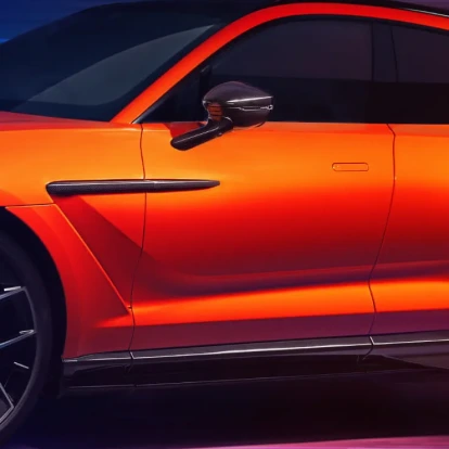 Upclose view of side of an orange Aston Martin DBX707